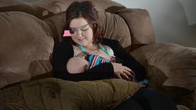 woman wearing google glass breastfeeding her child