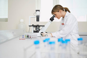 Scientist Using Microscope In Laboratory
