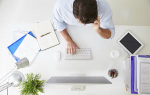 Overhead View Of Businessman Working At Computer In Office